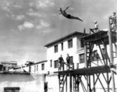 A high diver makes a giant, albeit graceful, leap into the pool. Below, a group of swimmers gets set during a 1942 swim meet.