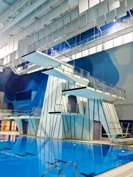 The aquatics center includes two internationally sanctioned 50-metre, ten-lane swimming pools; a warm-up pool; a 5-metre deep diving tank with 3-, 5-, 7.5- and 10-metre platforms; and dryland training facilities with dive pits and trampolines. Motorized blinds in the training pool space allow privacy when needed for women’s or special-group training.