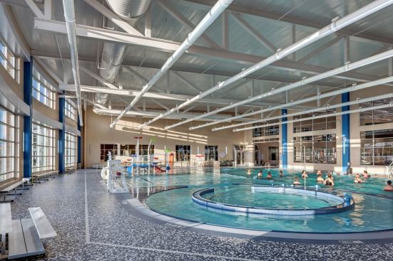 The leisure pool features a current channel, play features aimed at small children to teens, a water slide, zero-depth entry, lap lanes and a therapeutic seating area. The large windows and opening toward the right visually connect this space with the competition area.
