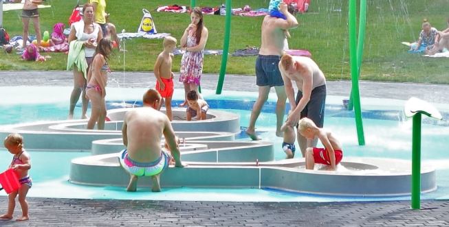 In the gentler pad for smaller children, a Discovery Stream with several interactive weirs and bubblers winds throughout the spraying shoots of grass, giant poppies and bloom canopies.
