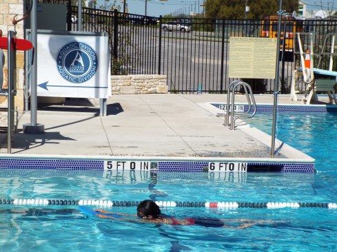 Notice the school bus in the background? In addition to covering the costs of the course and providing goggles and swimwear, SwimATX arranges for schools to deliver students to city pools during school hours. 