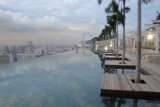 Designed by architect Moshe Safdie, the SkyPark pool amenities span the width of all three soaring Marina Bay Sands hotel towers, 626 feet (55 stories) above the ground. It is the world’s largest infinity-edge pool at that height and has a 213-foot cantilever edge. Appearing to float

like a ship across the top of the building, the pool literally spills over the astonishing 478-foot vanishing edge.
