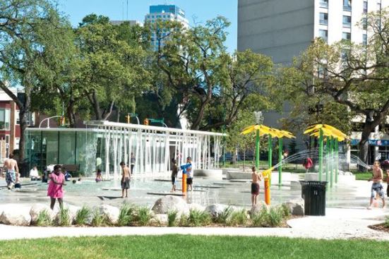 The glass structure housing

the washrooms, lockers and mechanical room is perhaps one of the

most striking elements of the Central Park aquatic features. The

building was conceived to be literally transparent for two reasons:

to fit into the overall aesthetics and to discourage any unlawful

activity. The spatial considerations of the structure were somewhat

restrictive and resulted in a custom-built manifold and

water-treatment system. Inside, the washrooms were built with

environmentally sensitive low-flow toilets, and motion-detecting

faucets. Further connecting the building to the park aesthetics, a

shade canopy runs parallel to the building, and is topped by a

stainless steel trough with water flowing into the wading

pool.